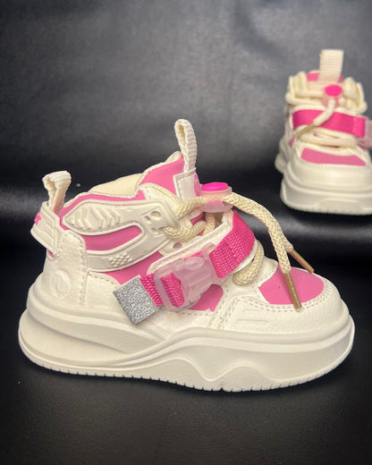 White and pink children's sneakers on a black background